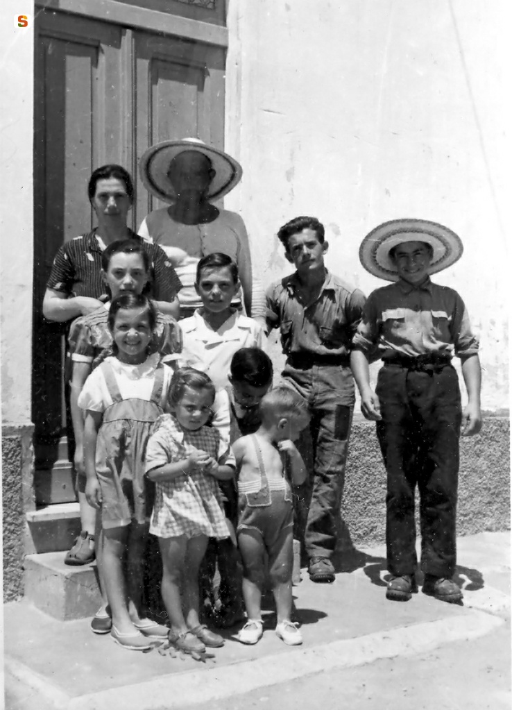 Famiglia davanti all'ingresso di una casa colonica