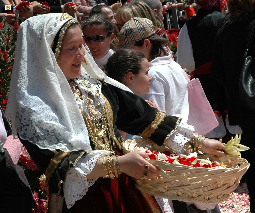 Donna in abito tradizionale si predispone al rito de sa ramadura
