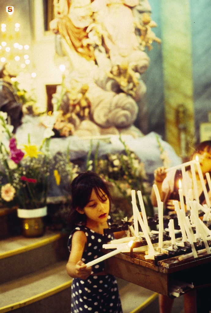 Bambine accendono una candela
