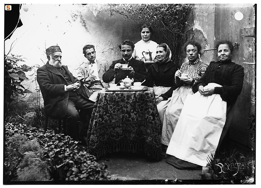 Giulio Pili, al centro, con la famiglia, seduti  attorno a un tavolino in cortile