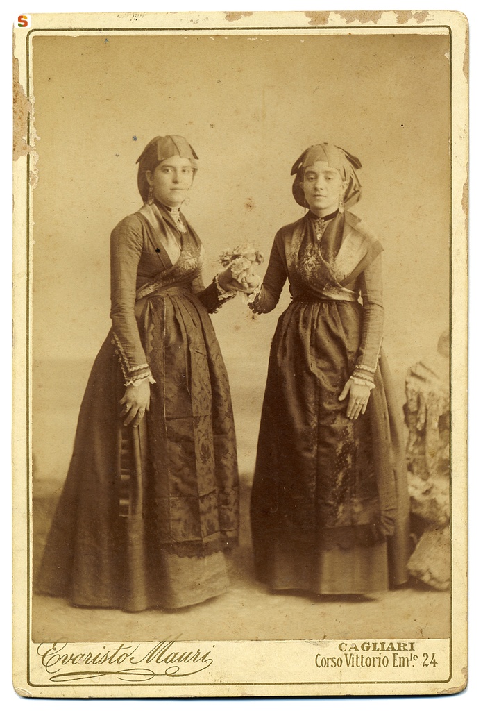 Due giovani donne in abito tradizionale con fiori in mano
