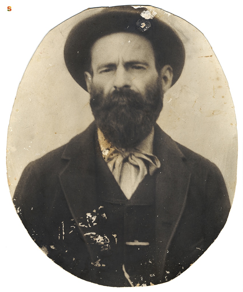 Ritratto a mezzobusto di uomo in abito borghese con cappello e cravatta a fiocco